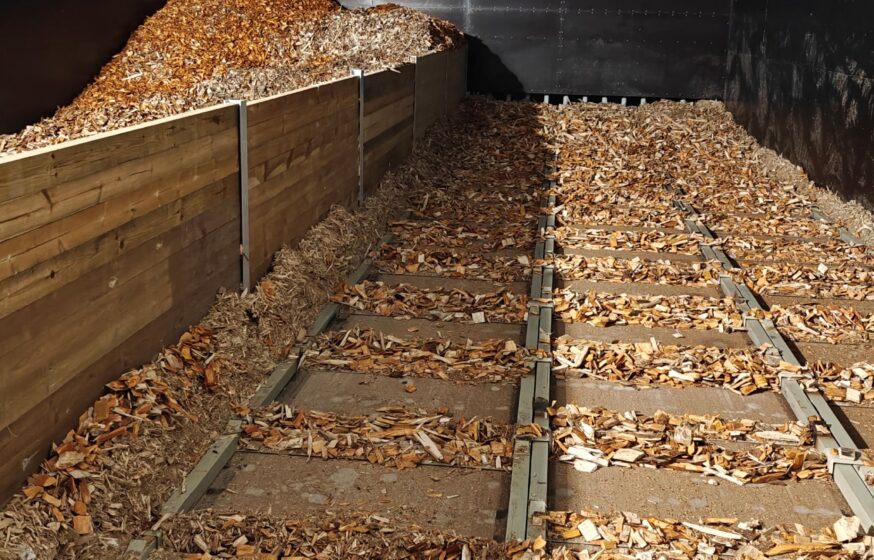 Biomass fuel storage with moving floor system for district heating boiler house