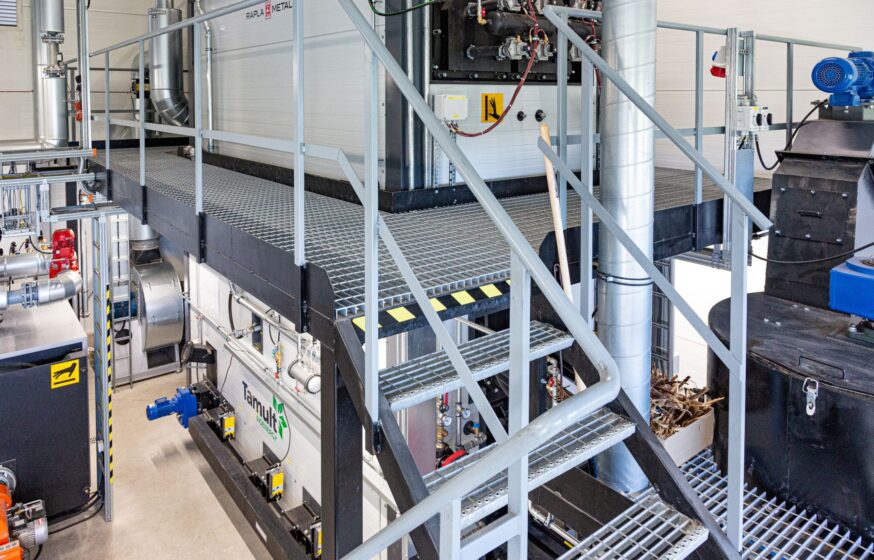 Biomass moving grate boiler with integrated fuel feeding system